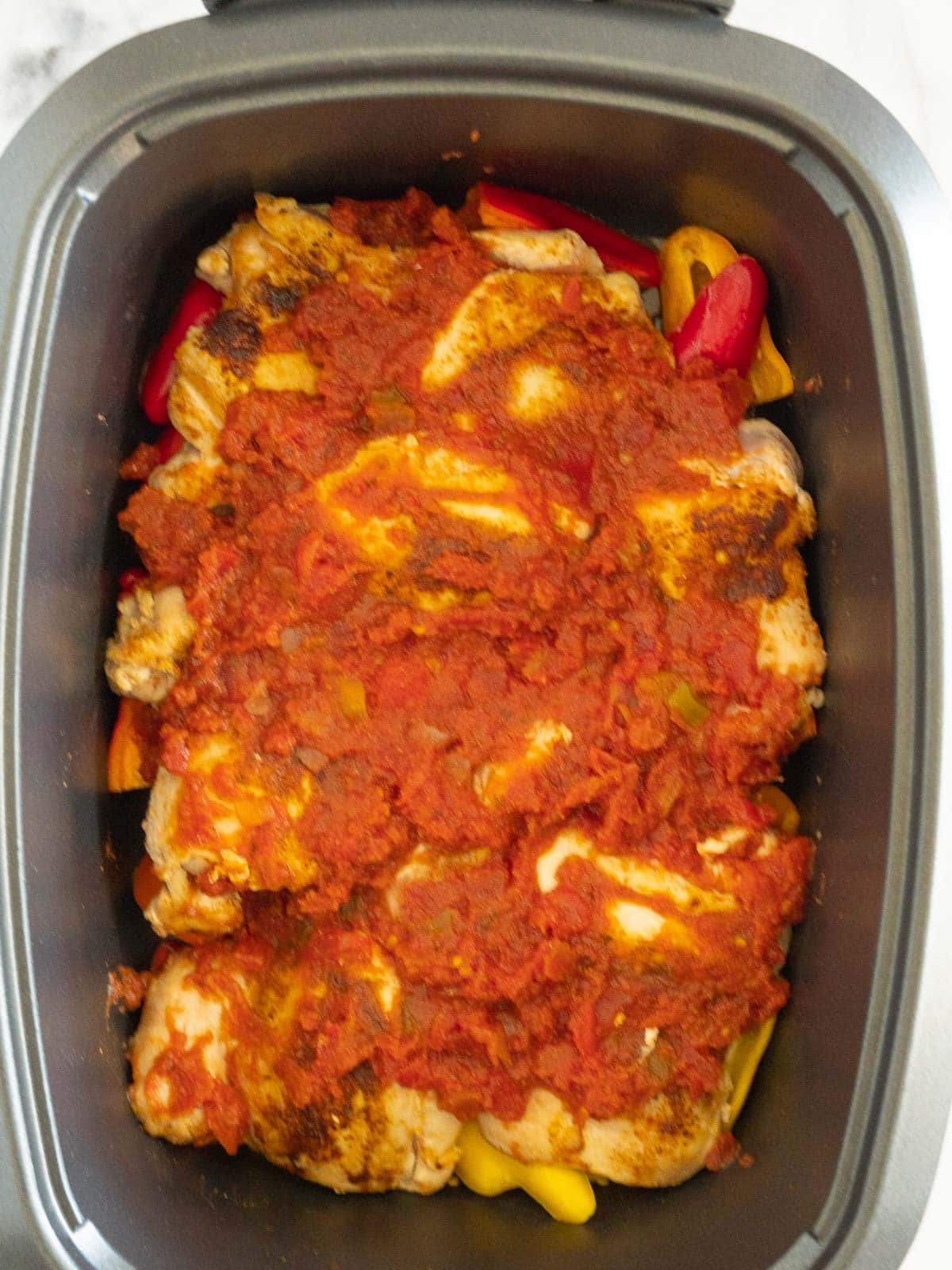 Salsa over chicken and peppers in slow cooker.