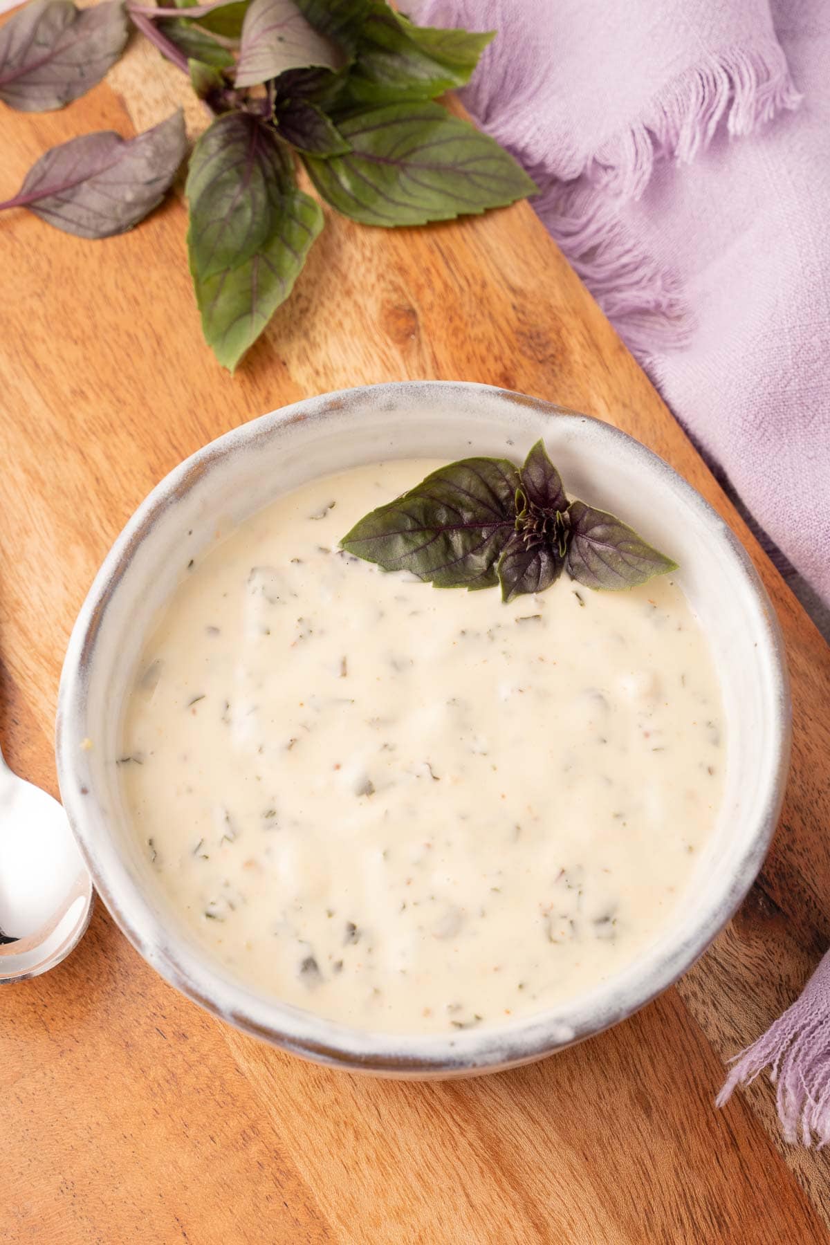 Garlic basil sauce in bowl on cutting board.