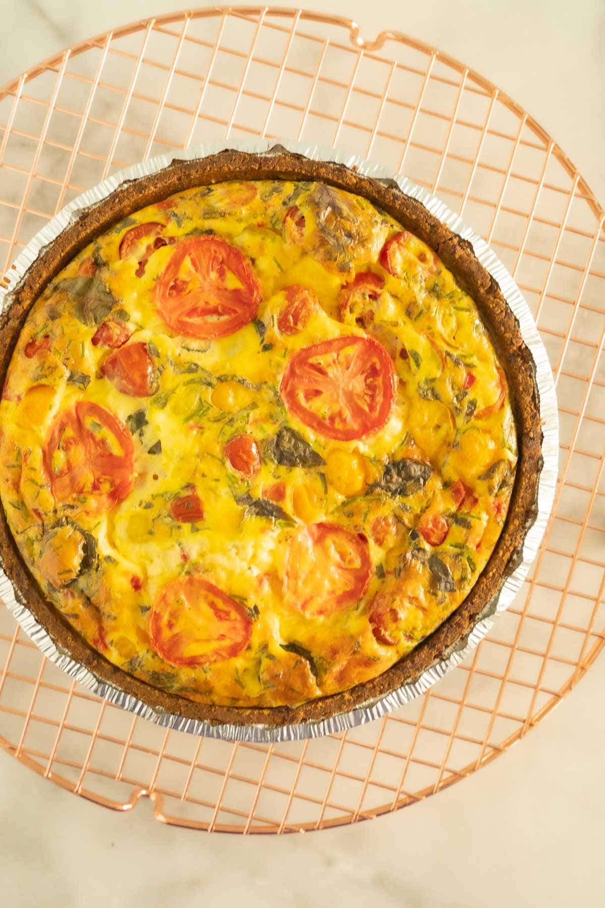 Baked tomato basil quiche on cooling rack.