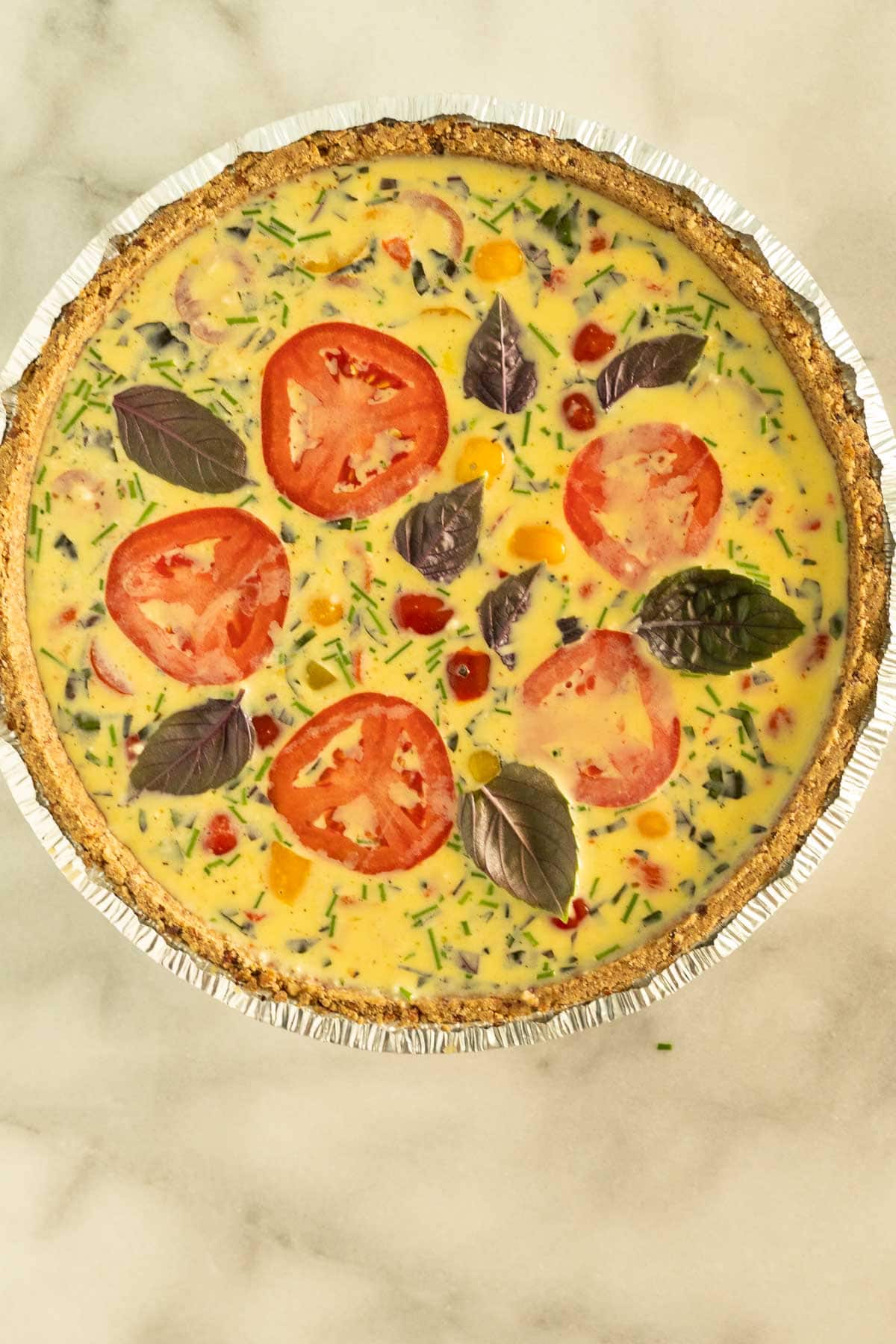 Eggs, basil, tomatoes, red peppers, cheese in pie crust.