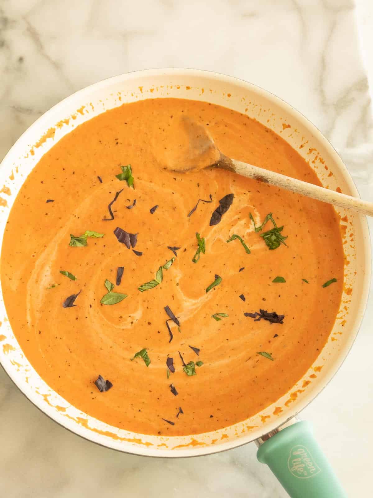 Italian pink sauce with basil in skillet.