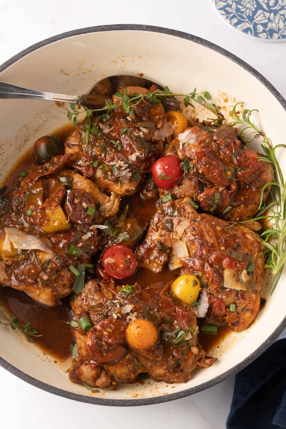Pan Roasted chicken thighs with burst tomatoes in large pot.
