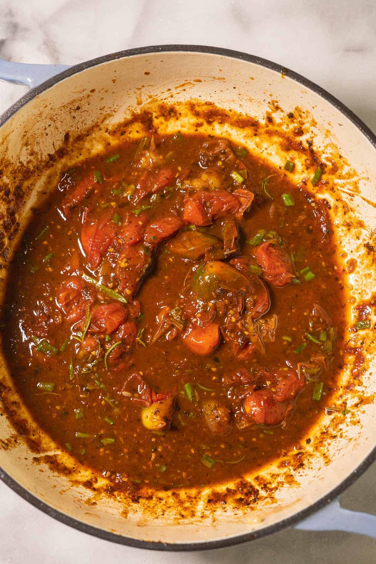 Burst tomatoes, balsamic sauce in pot.