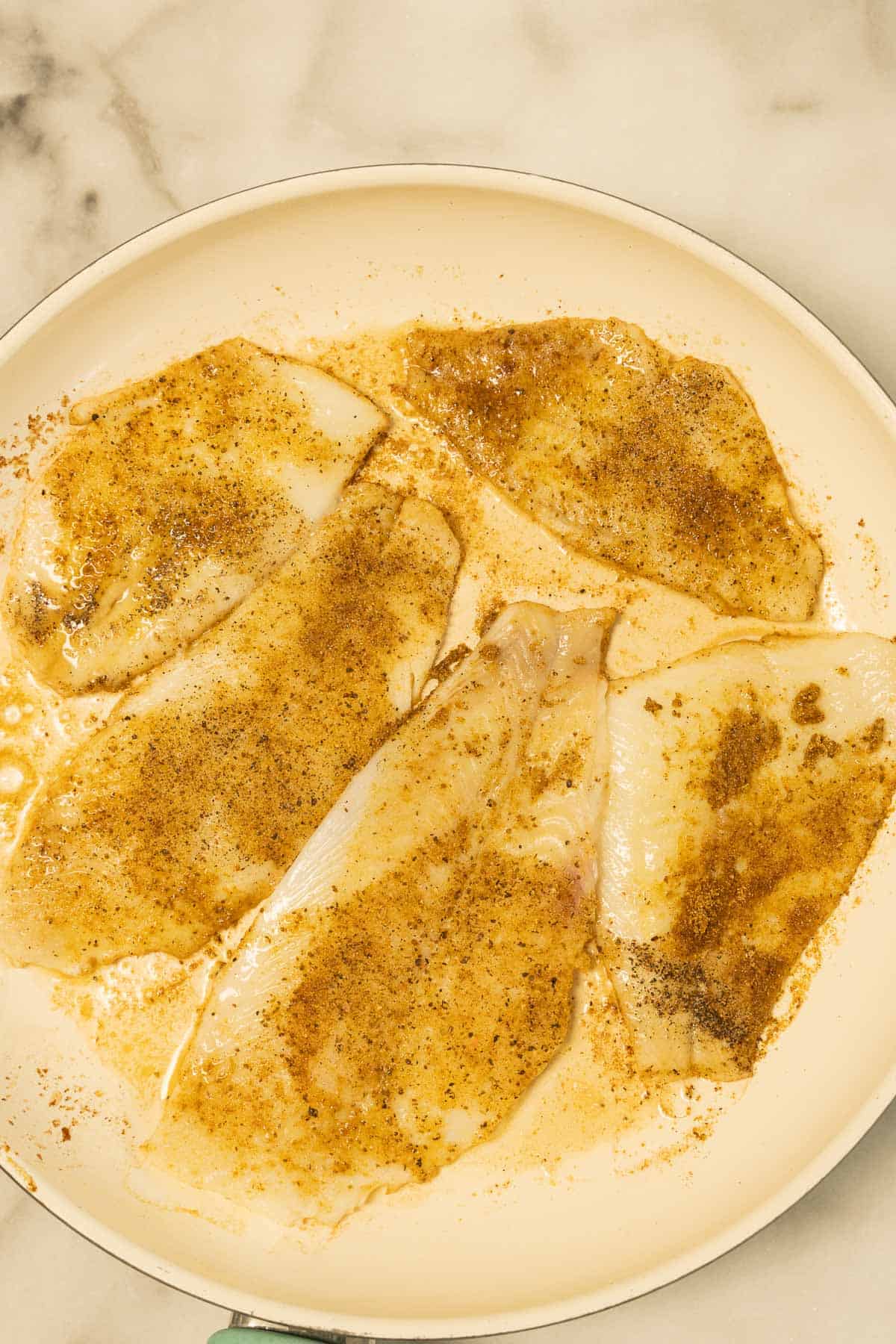 Pan fried flounder fillets in skillet.
