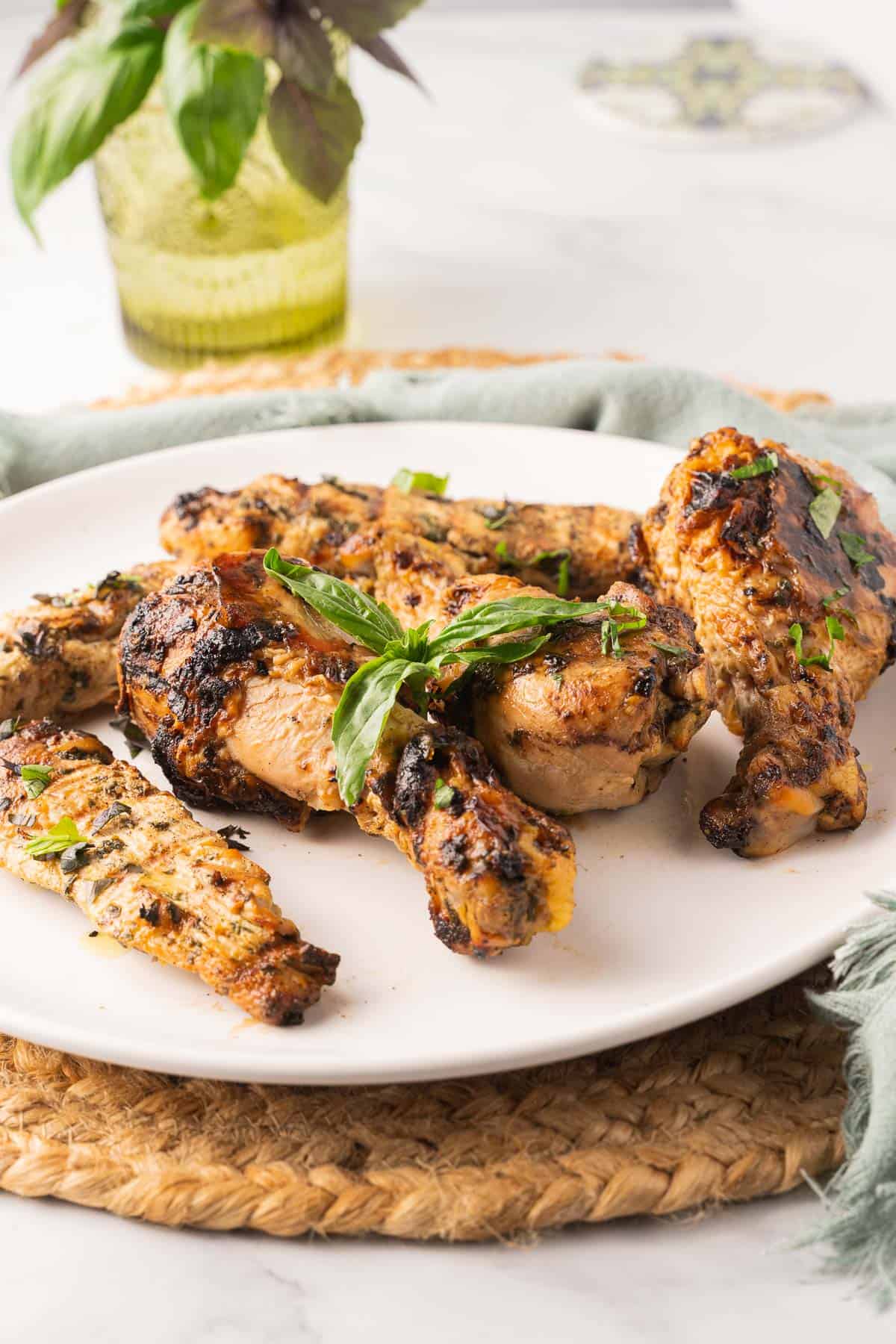 Basil chicken marinade chicken legs on white plate.