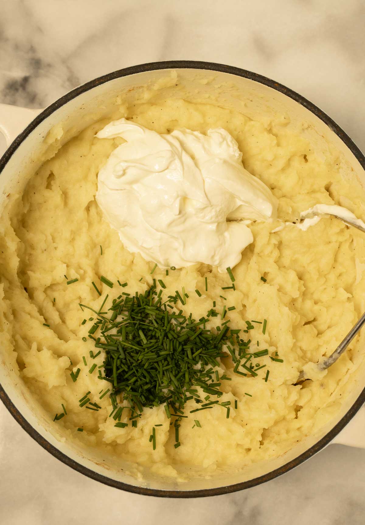 Mashed potatoes with sour cream and chives in pot.