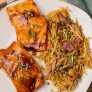 Two air fried teriyaki salmon fillets with broccoli slaw on plate.