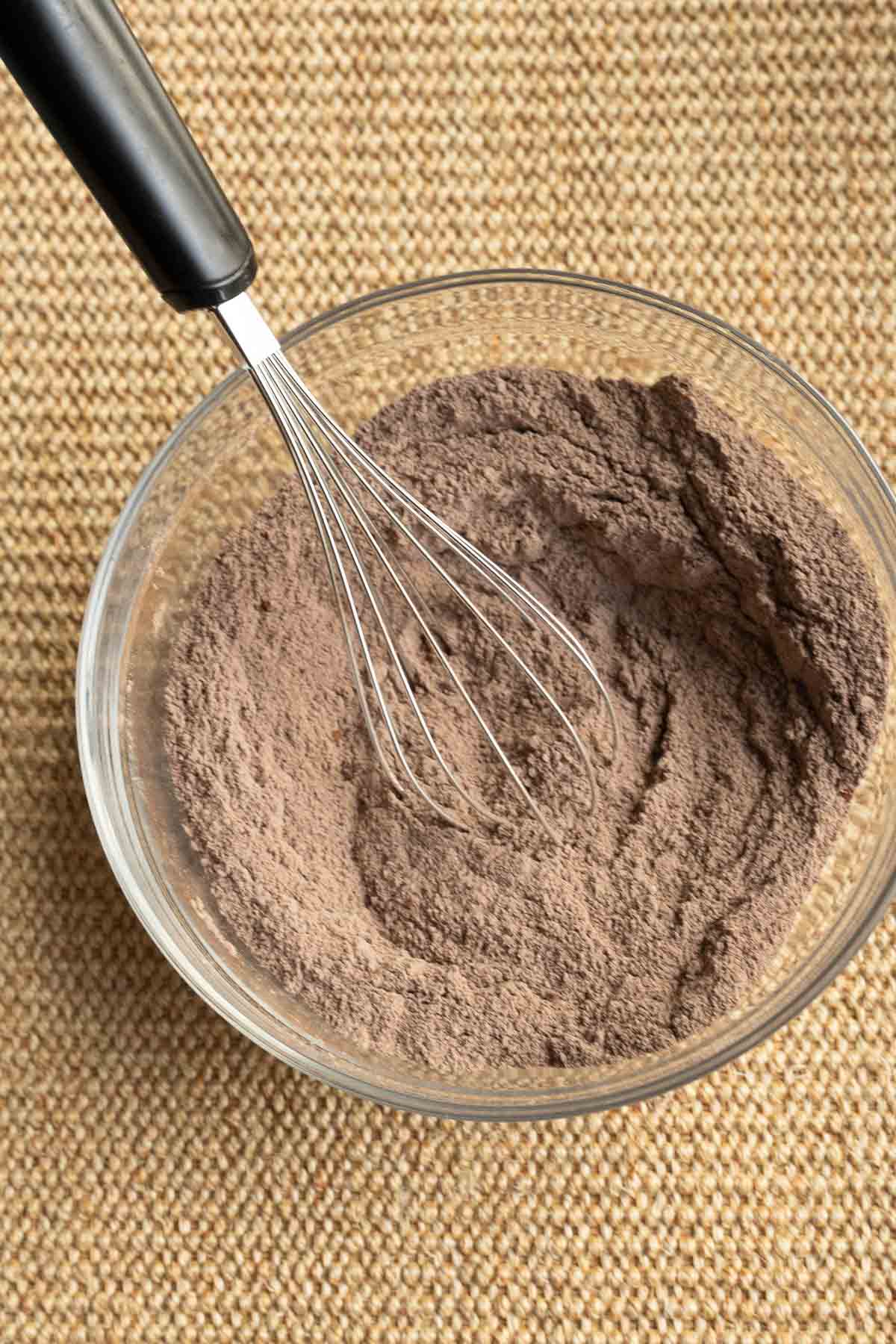 Flour, cocoa powder whisked in glass bowl.