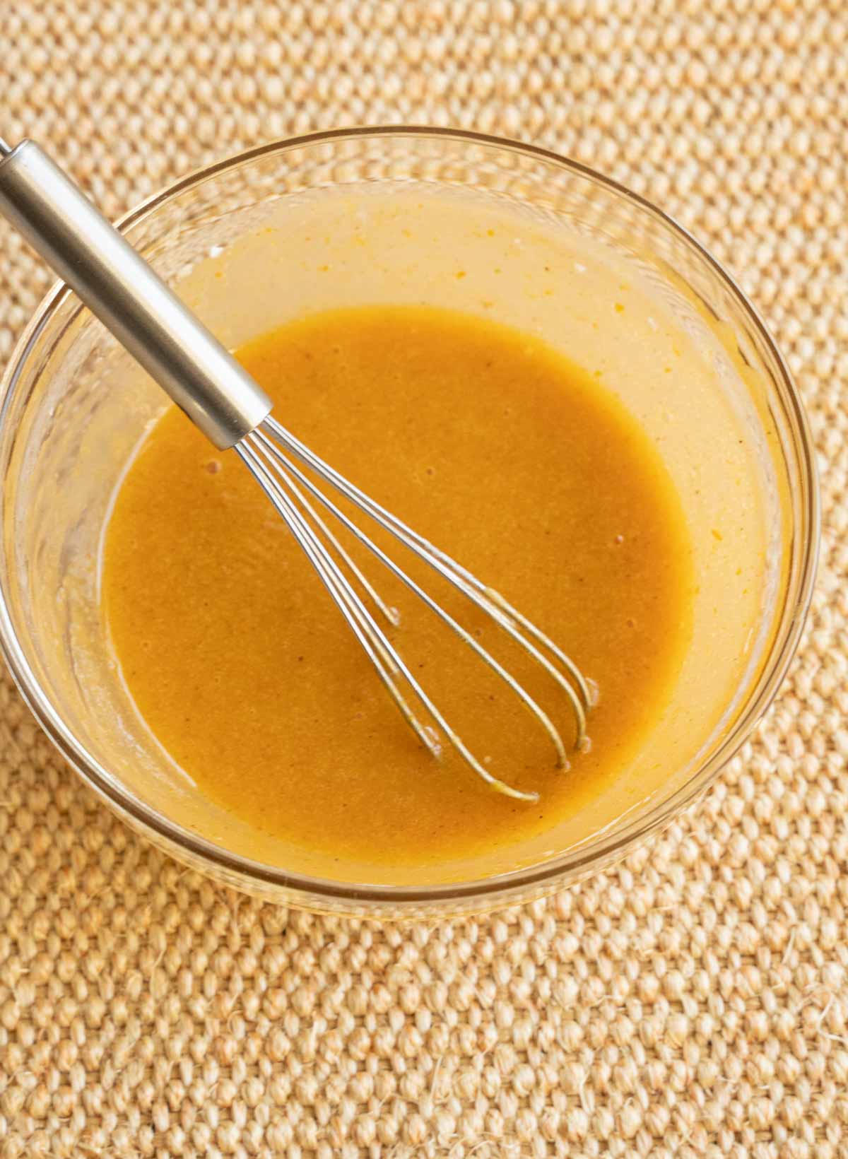 Pumpkin glaze in glass bowl with whisk.