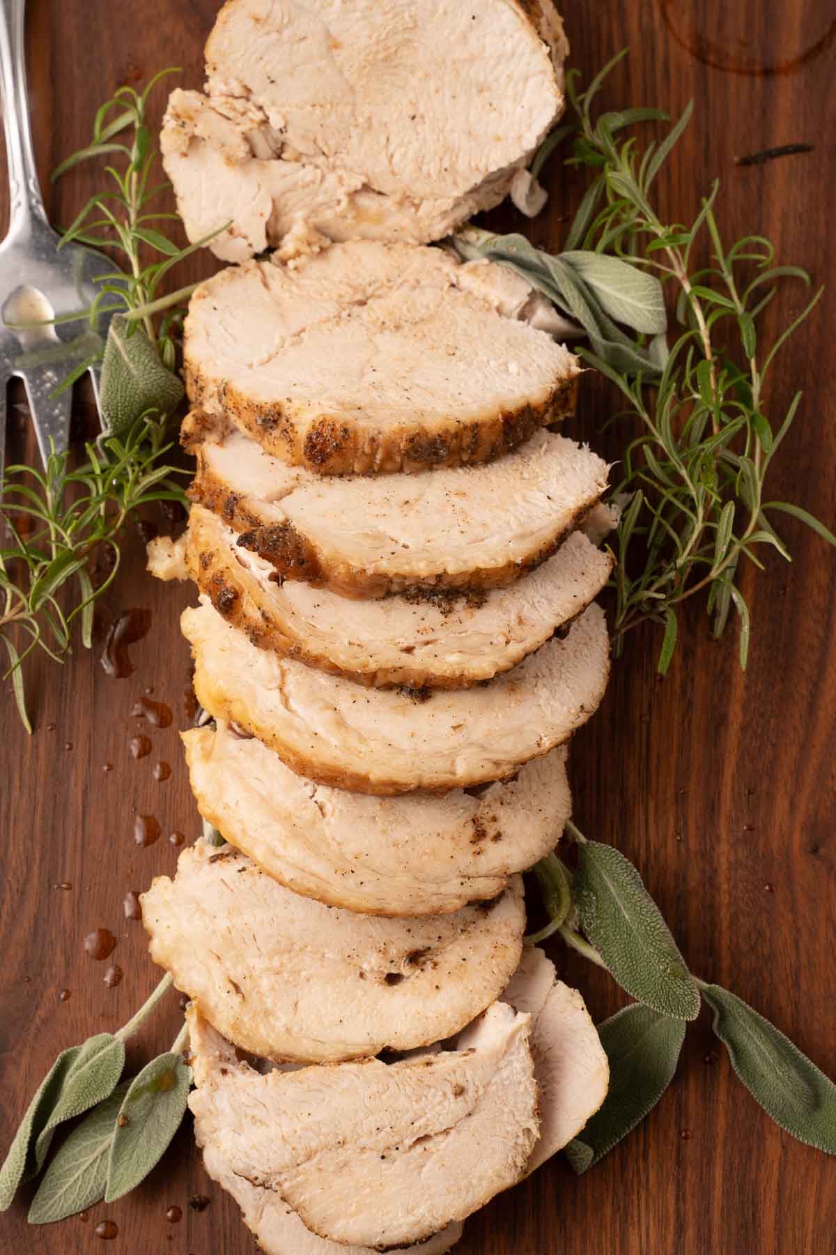 Sliced boneless turkey breast on cutting board.