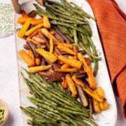 Roasted Carrots and Green Beans on platter with rust colored napkin.