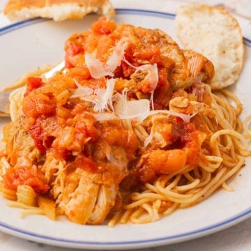 Slow Cooker chicken cacciatore with spaghetti on plate.