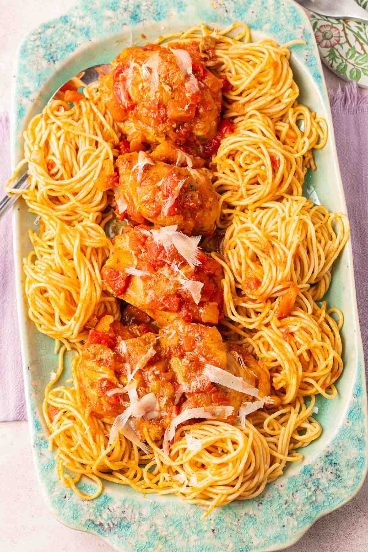 Slow cooker chicken cacciatore and spaghetti on green platter.