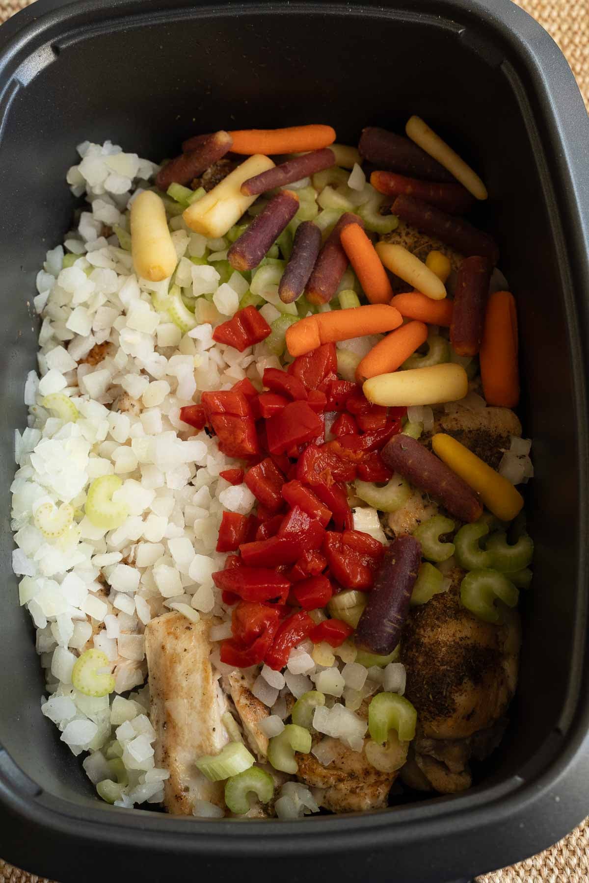 Onions, celery, carrots, pepper, chicken in slow cooker.