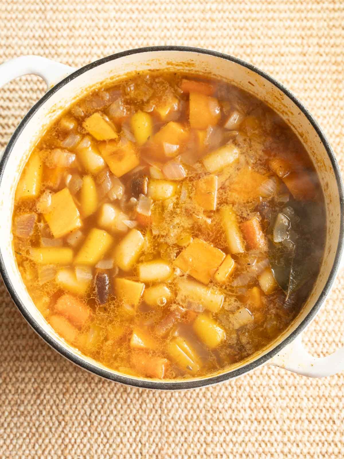 Carrots, sweet potatoes, onion, broth, seasonings simmering in large pot.