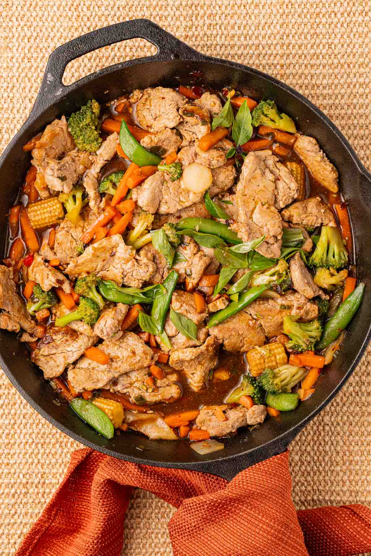 Thai Basil Pork and vegetables in cast iron skillet.