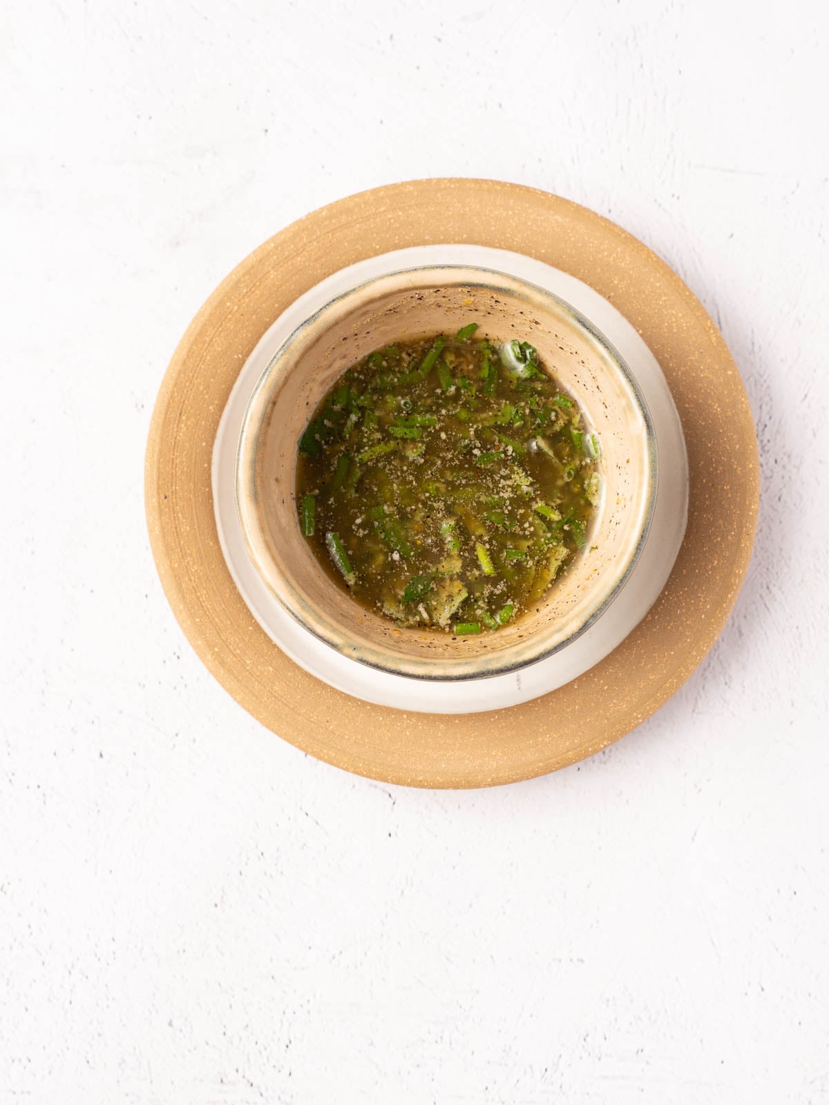 Melted butter, chopped herbs and seasonings in bowl.