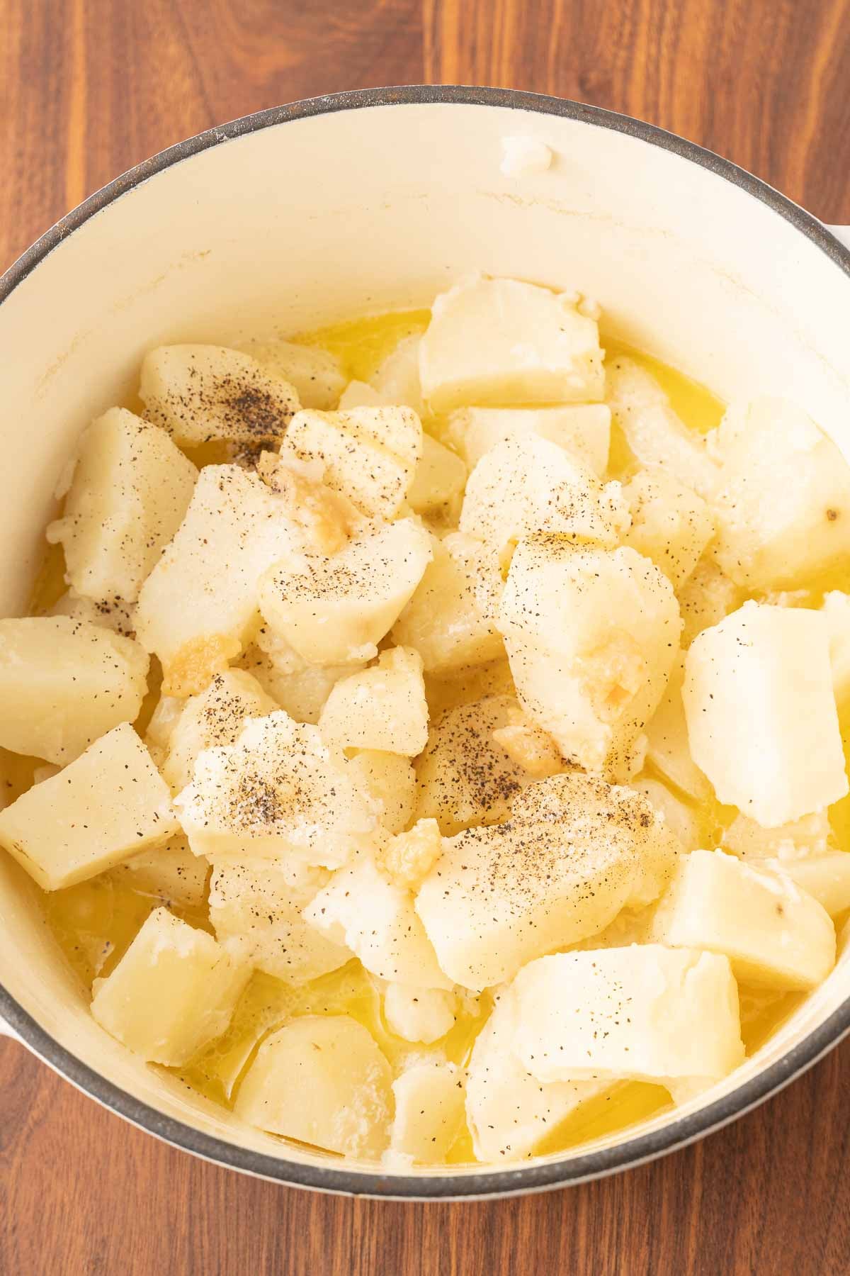 Cooked russet potatoes with butter and half and half in large pot.