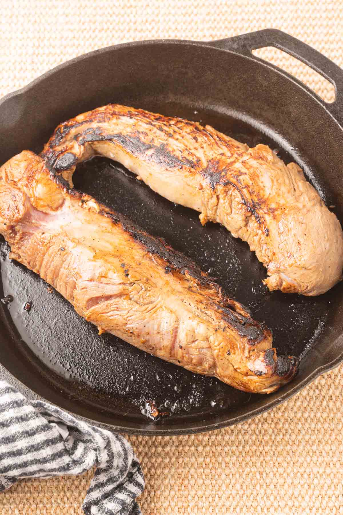 Pork tenderloin in cast iron skillet.