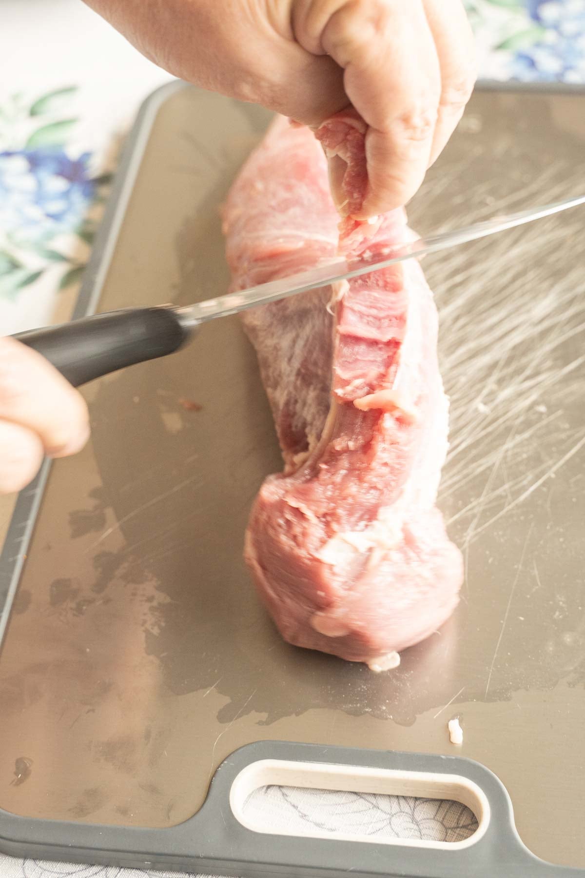 Removing silver skin from pork tenderloin.