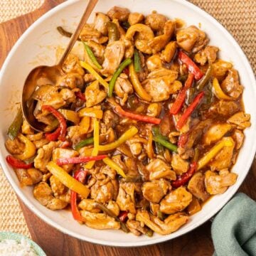 Chicken and Pepper Stir Fry in skillet with large serving spoon.