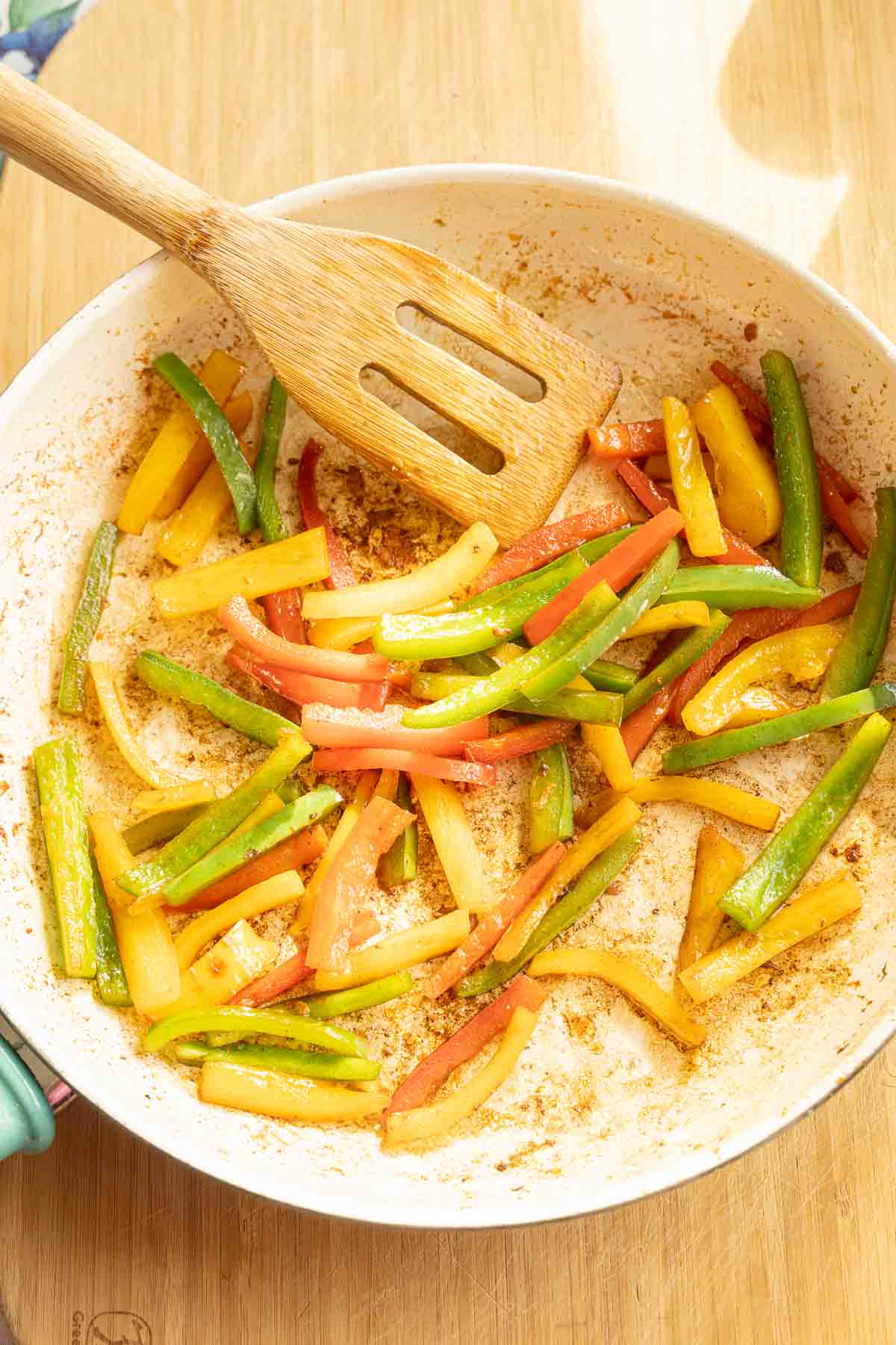 Stir frying peppers in skillet.
