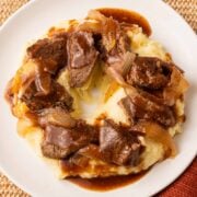 Slow Cooker Sirloin steak and mashed potatoes on white plate.