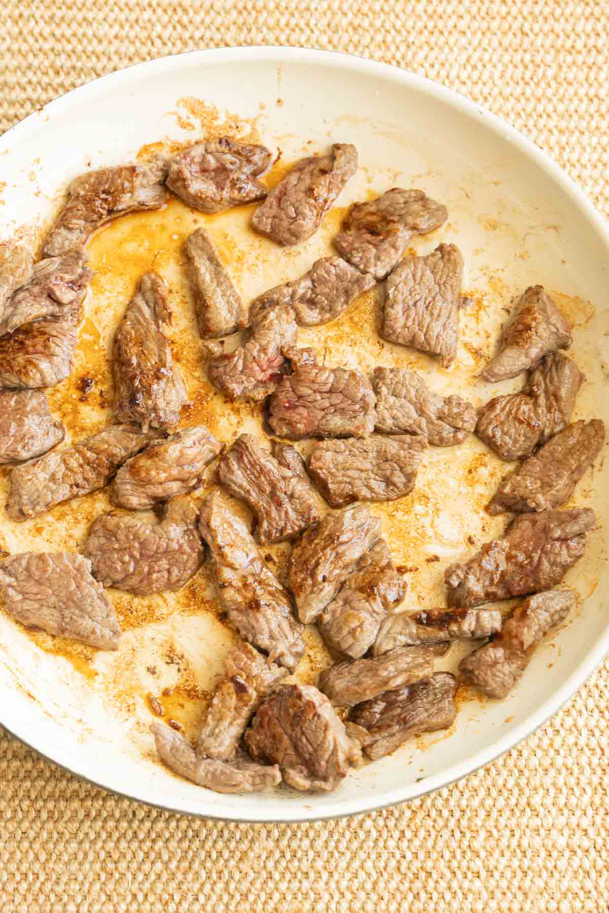 Browned top sirloin strips in skillet.