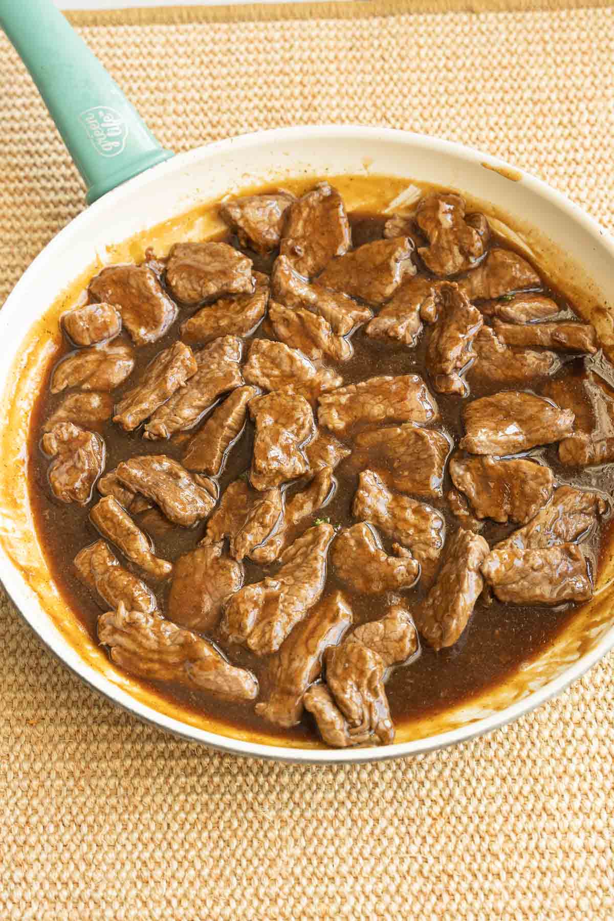 Beef strips and sauce in skillet.