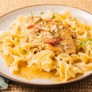 Marry me chicken without sun dried tomatoes sauce over noodles on plate.