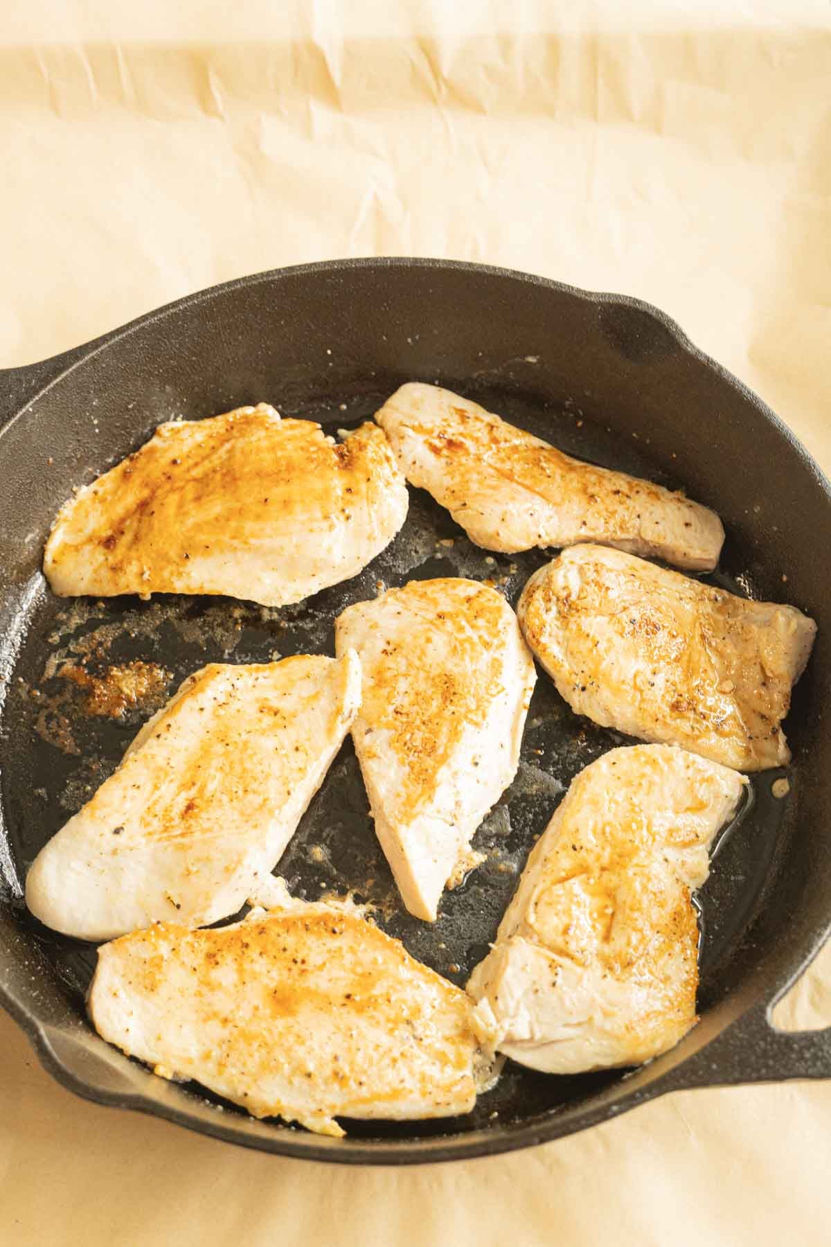 Skillet with browned boneless chicken.