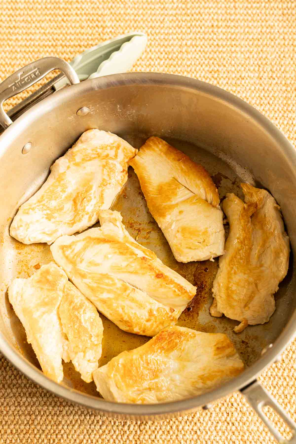 Browned chicken breast in skillet.