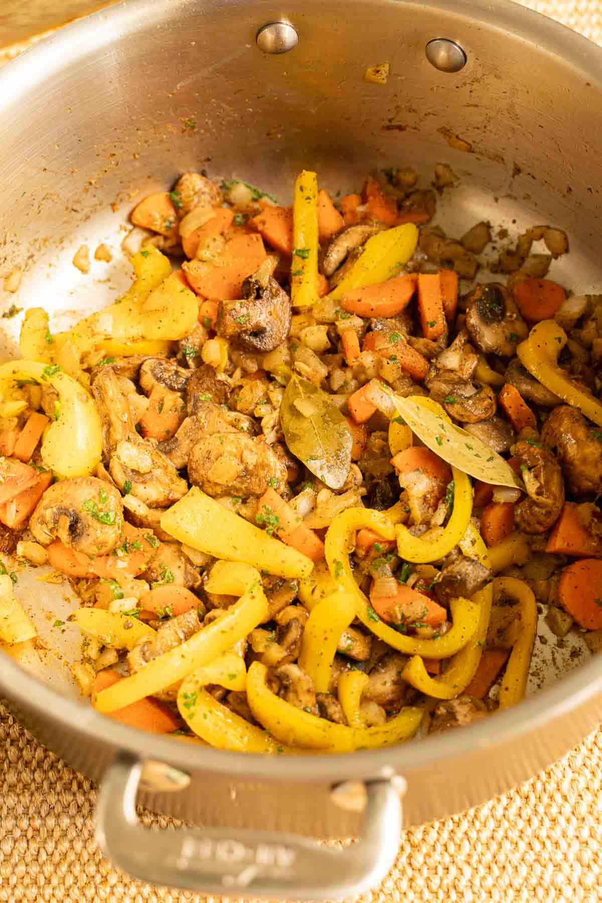 Adding seasonings to skillet of vegetables.
